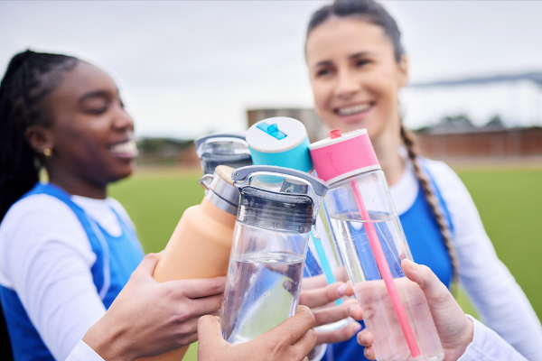 People clinking water bottles together