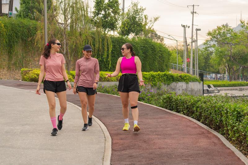 Stock photo of three women walking on a paved track