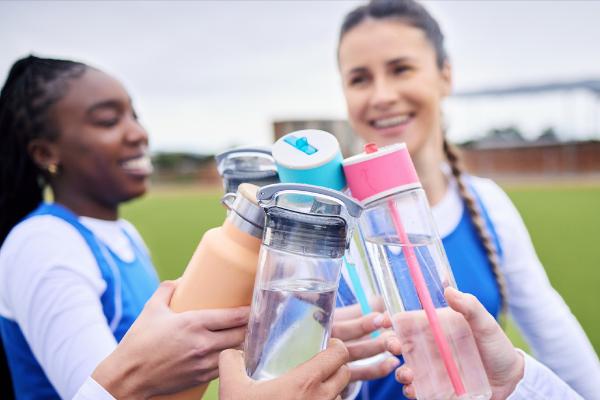 People clinking water bottles together