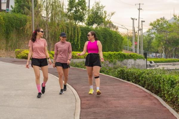 Stock photo of three women walking on a paved track