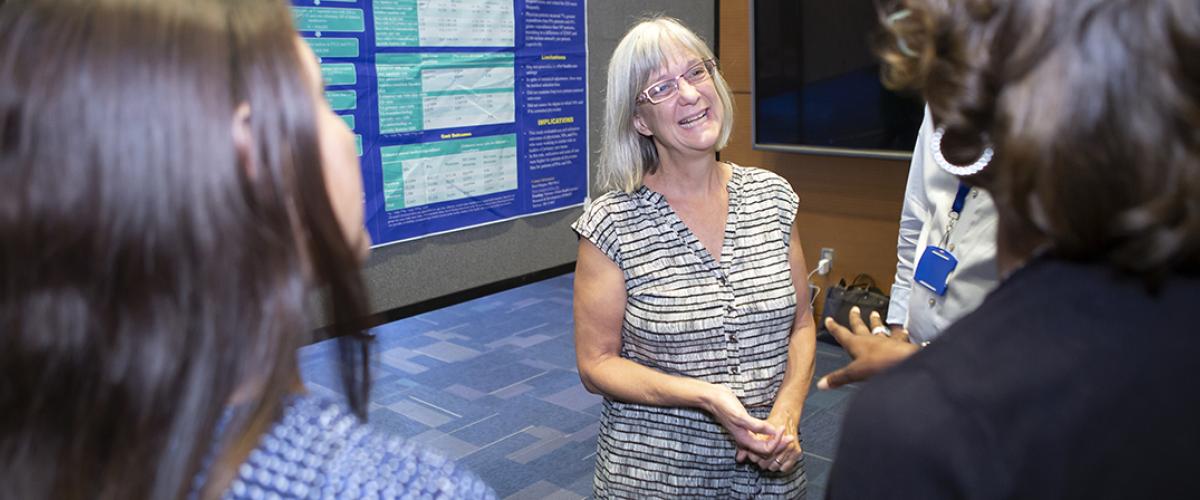 faculty member gives poster presentation