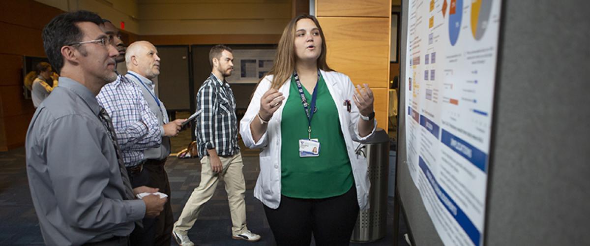 medical student presents research to faculty