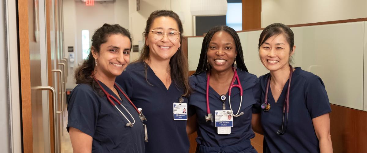Students wearing scrubs while standing in a hallway