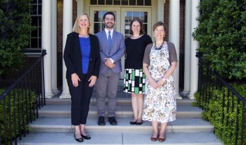 group photo of four people outside a building