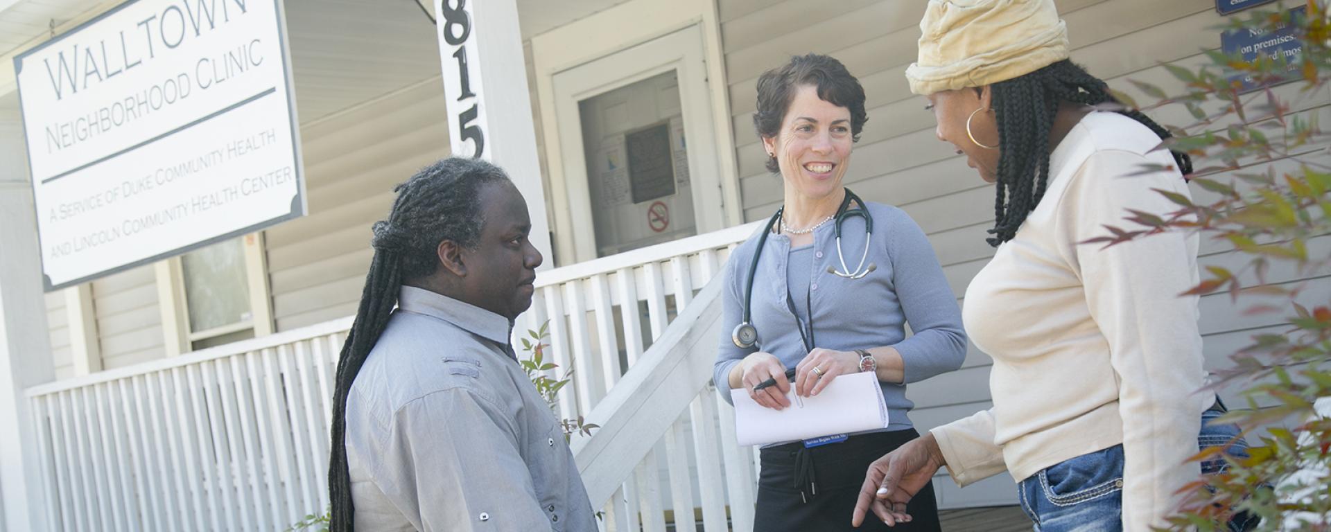 a PA speaks with two patients at community clinic