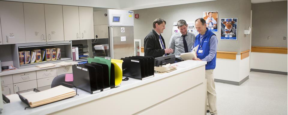 three men in the employee health clinic speaking