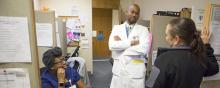 physician speaks with two nurses in preceptor room